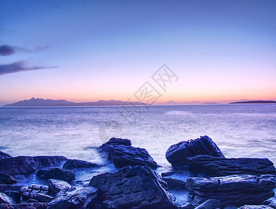 赫布里底岩石湾的石滩和悬崖 2月日落的蓝调 粉色地平线崎岖岛屿海滩海洋场景高地岩石巨石旅行风暴背景