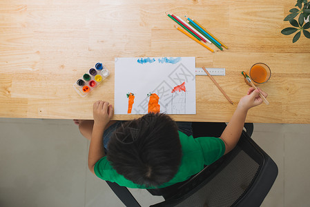 小男孩在桌子上画画教育绘画作业幼儿园艺术学生白色男生家庭学校背景图片