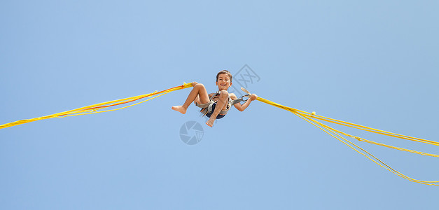 阿细跳月男孩跳跃在蹦床线上活力童年乐趣娱乐天空幸福灵活性蹦极行动活动背景