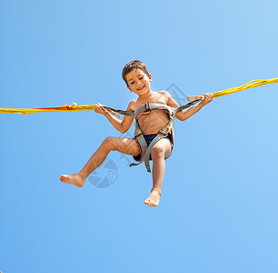 阿细跳月男孩跳跃在蹦床线上幸福活动男生乐趣灵活性童年运动公园逗乐微笑背景