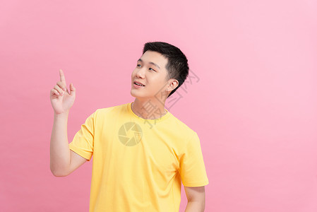 穿着粉红背景孤立的黄色T恤衫 身穿白色短袖圆背面成人快乐手指男人幸福男性背景图片