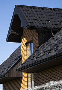 棕色波纹金属型材屋顶安装在带阁楼窗户的现代房屋上 波纹板屋顶 金属型材波浪形屋顶 现代屋顶由金属制成 金属屋面建造溢洪道覆盖物住重叠高清图片素材