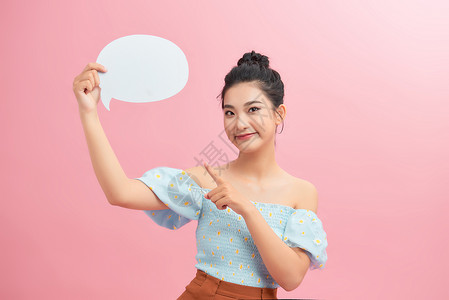 粉红色背景中一位兴奋的年轻女子的画像 她拿着空洞的讲话泡泡 手指向上孤立女士快乐空白气泡演讲女孩日本人高清图片素材