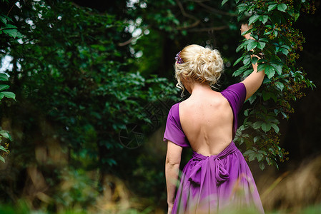 身着一束花束的银色礼服的金发女模特金发女郎森林花圈白色化妆品绿色发型裙子背景背景图片