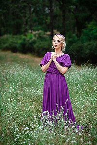 身着一束花束的银色礼服的金发女模特背景绿色森林花圈裙子金发女郎化妆品发型白色背景图片