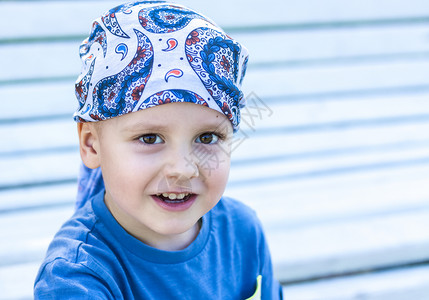 小男孩带着头巾一个小男孩的肖像 带着喜悦微笑背景