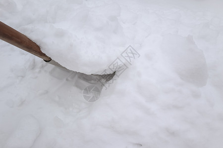 冬天暴风雪过后用铲子扫雪背景图片