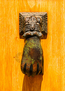 青铜门门有黄铜敲门的形状 像一只手 漂亮的入房门手指建筑学金属入口旅行木头青铜乡村橡木装饰背景