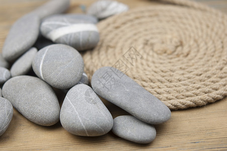 灰色鹅卵石与麻绳在木制的桌面空间上用于文本 禅意石头平衡冥想温泉矿物卵石金字塔团体白色岩石背景图片