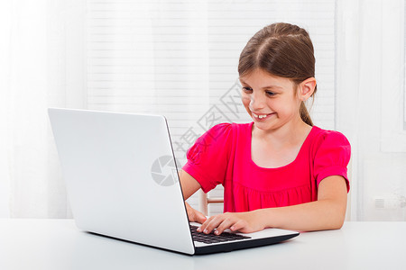 使用笔记本电脑的小女孩互联网乐趣技术学习阅读后代女性喜悦通讯桌子背景图片