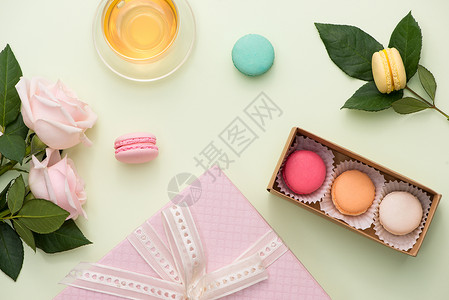 法国马卡龙 许多变异的甜甜玛卡龙 在餐桌上装满了粉红玫瑰花束的盒子里咖啡粉色礼物蛋糕甜点花朵白色食物巧克力桌子背景图片
