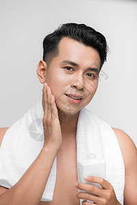 洗手间里的亚裔男人 使用面部润色液镜子推杆成人洗剂皮肤卫生润肤护理保湿浴室身体护理高清图片素材