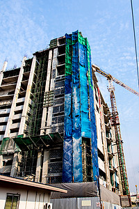 正在兴建的高楼大楼工作起重机建筑商业天空城市蓝色脚手架工程背景图片