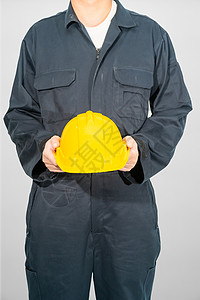 站在蓝色封面上站着的工人 都拿着硬帽工作服安全帽头盔员工手臂安全制造业职业检查员帽子背景图片