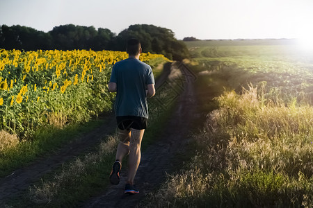 日落时人们沿着小路慢跑训练运动运动装运动员男性速度男生成人保暖赛跑者背景图片
