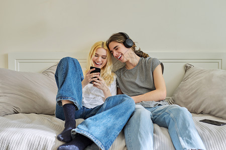 快乐笑笑嬉笑的青少年男女用智能手机一起玩得开心愉快幸福成人电话学生女士男性乐趣友谊女孩夫妻互联网高清图片素材