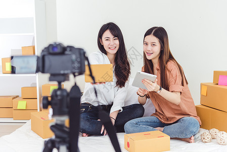 两名亚洲女性使用数码摄像机录制和展示新产品广告 Vlog 和影响者的概念 人们兼职工作和职业 使用技术的青少年创造者高清图片素材