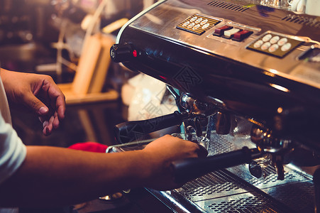 专业男性咖啡师在餐厅或咖啡店用咖啡机手工制作咖啡的特写镜头 人与生活方式 商业食品和饮料的概念 店主主题店铺高清图片素材
