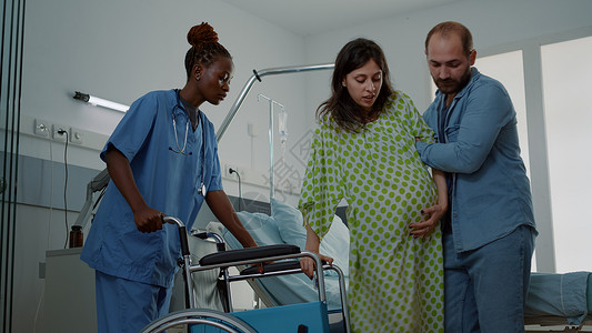 白种男子在医院病房帮助怀孕妇女女士母亲腹部婴儿劳动男人技术父亲病人卫生手高清图片素材