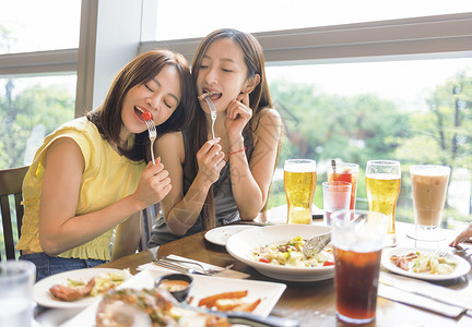 快乐的女朋友们在餐厅享受食物和饮料女士高清图片素材