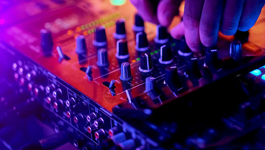 DJ在专业音响混音器上混合轨道的手 和监管者重点背景