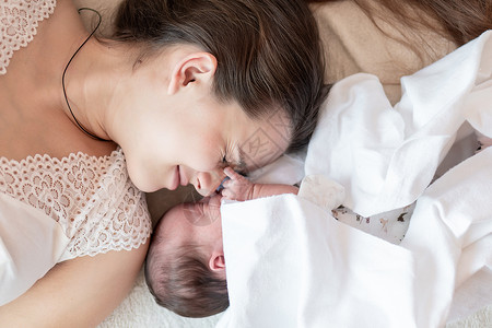 母性 婴儿期 童年 家庭 护理 医学 睡眠 健康 母性概念妈妈和新生婴儿的肖像 白色背景中裹着尿布 文本位置 特写 柔焦母亲生活可爱的高清图片素材