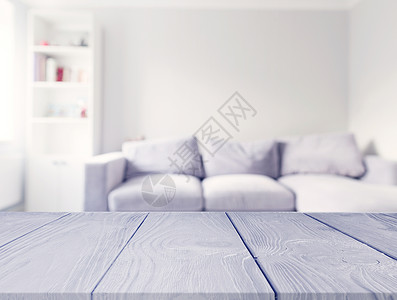 灰色木桌前面模糊的白色沙发起居室背景图片