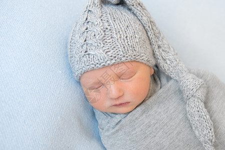 可爱的婴儿 穿着毛绒灰帽睡午睡灰色童年织物材料羊毛衣服男生孩子新生帽子羊羔绒高清图片素材