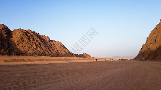 在埃及的沙漠 多岩石的沙丘 在蓝天和山脉的背景下 沙漠中一辆沙滩车上的孤独游客正走向红海 沙漠中的风景旅行蓝色四边形石头地质学晴背景图片