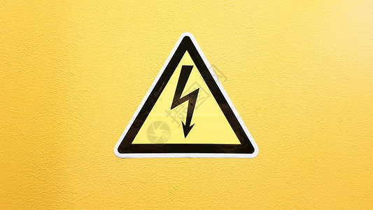 黄色金属三角形安全标志黄色和黑色粘在黄色的墙上 在三角小心的高压闪电小心危险电死亡注意力震惊冒险标签力量电压金属活力风险贴纸背景
