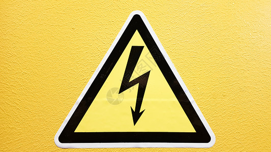 黄色金属三角形安全标志黄色和黑色粘在黄色的墙上 在三角小心的高压闪电小心危险电死亡电压震惊标签金属风险电气注意力警告活力贴纸背景