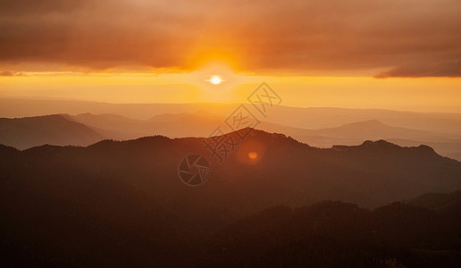 日落在山上风景爬坡太阳红色云景薄雾天空阳光橙子太阳耀斑背景图片