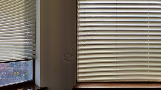 窗外的百叶窗是用来保护室内免受炎热和阳光照射的 室内的滚动门窗可以晒太阳风格遮阳棚射线条纹阴影办公室窗帘太阳房间窗户背景图片