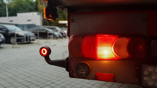 红色卡车老卡车卡车后方圆形红色标志灯的特写镜头 卡车尾灯 背景模糊 夜间在路上安全旅行的概念警告车辆玻璃驾驶反射机器塑料货车技术信号背景