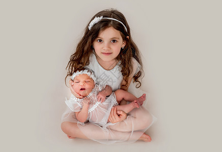 女童与新生姐妹家庭投标睡眠女孩姐姐新生婴儿拥抱兄弟女儿室内的高清图片素材
