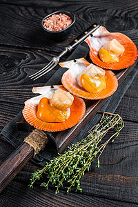 半壳扇贝木板上有草药 黑木本底 顶部视图的木板上的贝类熟食海鲜烹饪美食扇贝桌子食物奢华白色女王背景