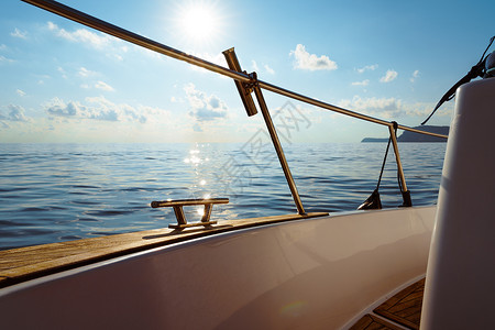 ipe甲板日落时在公海航行的白色游艇甲板帆船运输旅游血管运动蓝色日出金属阳光探索背景