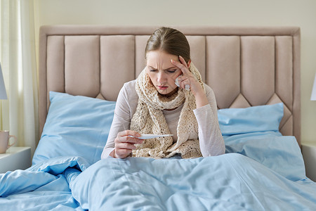 手上有温度计 坐在家中床上躺在床上的患病青年妇女症状卫生毯子过敏药品温度卧室保健痛苦发烧吹高清图片素材