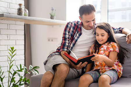 一个年幼的父亲和他的小女儿 读圣经著作头发圣经宗教学生太阳青春期孩子父母教育背景图片