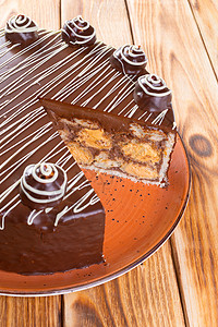 木制餐桌上在板盘上切巧克力蛋糕糕点食物甜点面包盘子可可背景图片