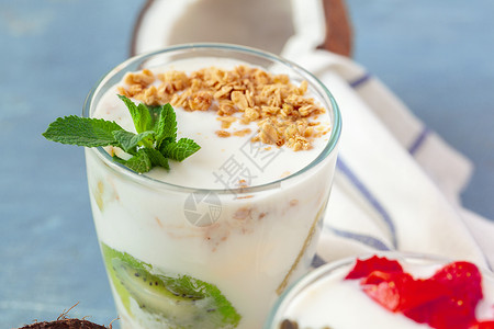 格拉条加酸奶和浆果的格拉诺拉 用来在桌上吃健康早餐玻璃种子奶制品营养燕麦饮食食物牛奶谷物活力背景