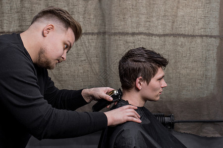 理发师或理发师用机器割下一个黑头发男的后脑勺店铺商业成人梳子男性男人服务工作顾客发型师理发店高清图片素材