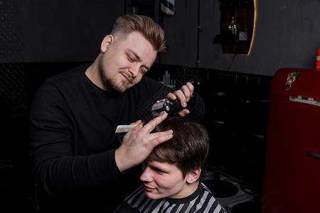 理发师或美发师的手在理发店里用自动机器和梳子为黑头发的顾客理发 理发修剪工作职业服务男人店铺造型师男性成人商业潮人高清图片素材