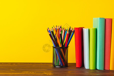 彩色铅笔杯和书本桌子金属铅笔图书笔筒补给品大学学校知识持有者背景图片