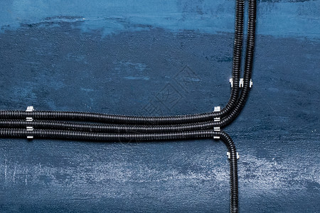 工业电缆电源连接和绝缘电线安装在墙上的电线维修安全力量管道金属住宅技术建筑工作房子软管高清图片素材