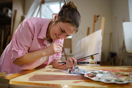 可爱的女人在艺术工作室的画布上作画 艺术家创作图片 艺术学校或工作室 使用颜料 画笔和画架 爱好和休闲的概念 工作区的女画家作坊女性高清图片素材