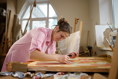 可爱的女人在艺术工作室的画布上作画 艺术家创作图片 艺术学校或工作室 使用颜料 画笔和画架 爱好和休闲的概念 工作区的女画家工艺艺术课高清图片素材