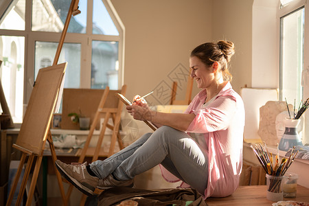 可爱的女人在艺术工作室的画布上作画 艺术家创作图片 艺术学校或工作室 使用颜料 画笔和画架 爱好和休闲的概念 工作区的女画家工艺作坊高清图片素材