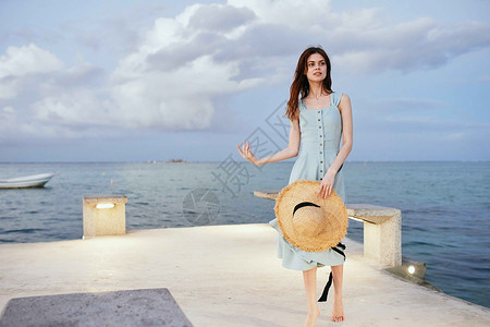 妇女在海滨附近穿着衣服 夏季休闲生活方式乐趣晴天海滩女士海洋假期喜悦游客帽子日落坐着高清图片素材