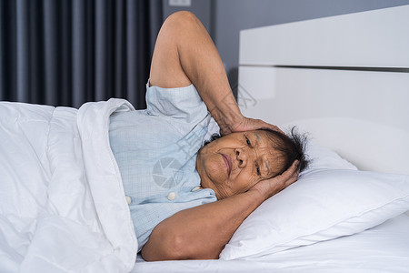 患有失眠症的老太婆想睡在床上头痛失眠睡眠女性说谎卧室孤独苏醒枕头退休背景图片